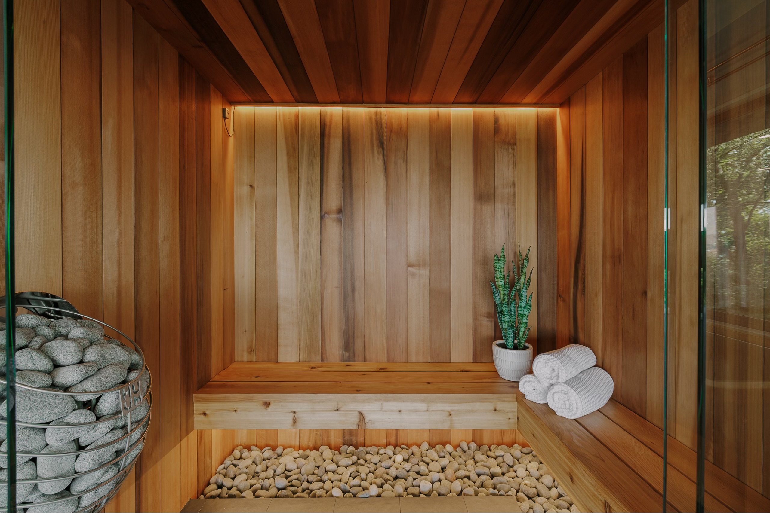 Custom cedar sauna with glass enclosure and integrated lighting